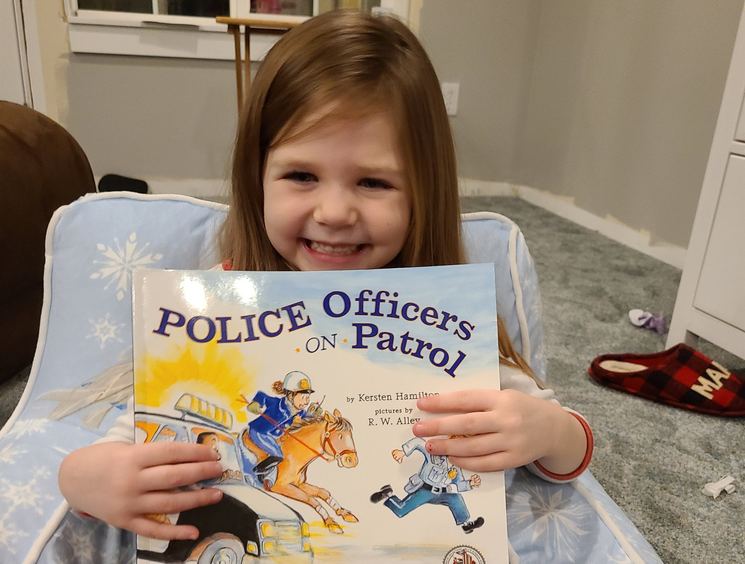 Gracie holds up a book sent to her as part of the Dolly Parton Imagination Library.